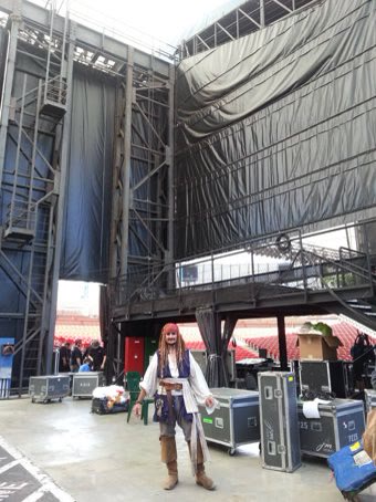 Capt'n Jack Spareribs backstage at Shoreline Amphitheatre, massive stage rigging and road cases behind him.