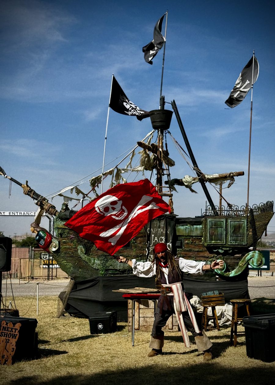 The pirate shipwreck's red skull-and-crossbones flag, prominent against the ship's rigging.